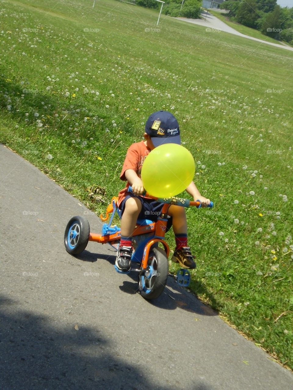 Niño en un triciclo con un globo amarillo