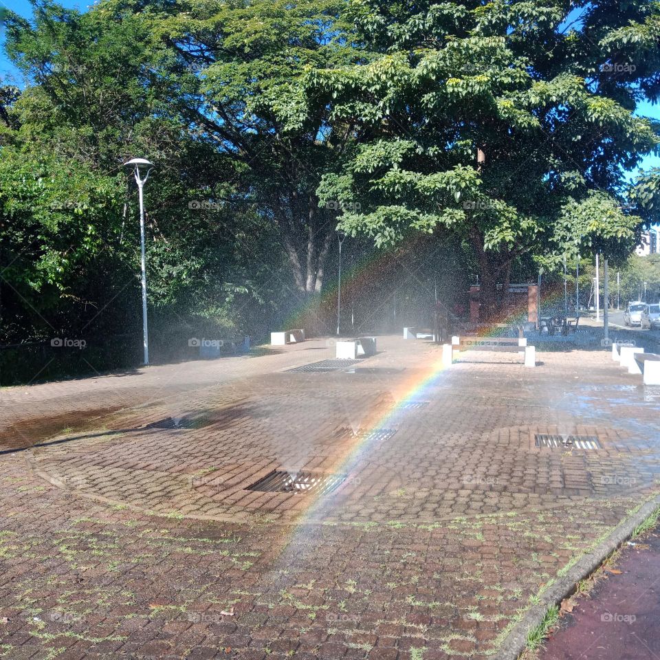 A rainbow formed from sprinkles in a city walking path- Parque Linear Amparo-SP