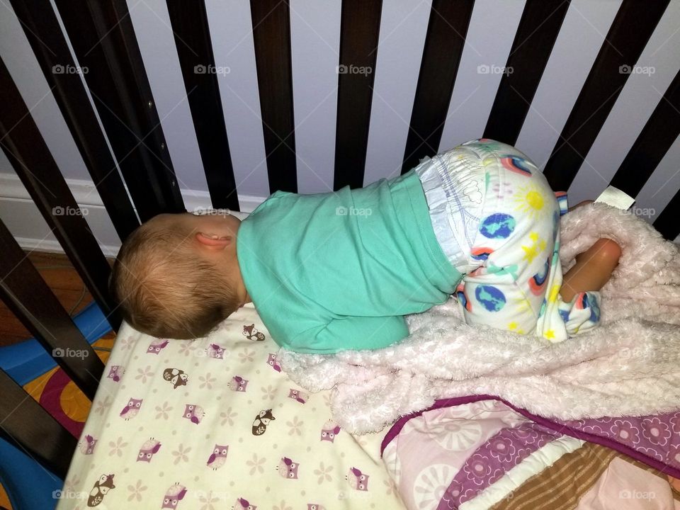 Baby / toddler sleeping comfortably in crib