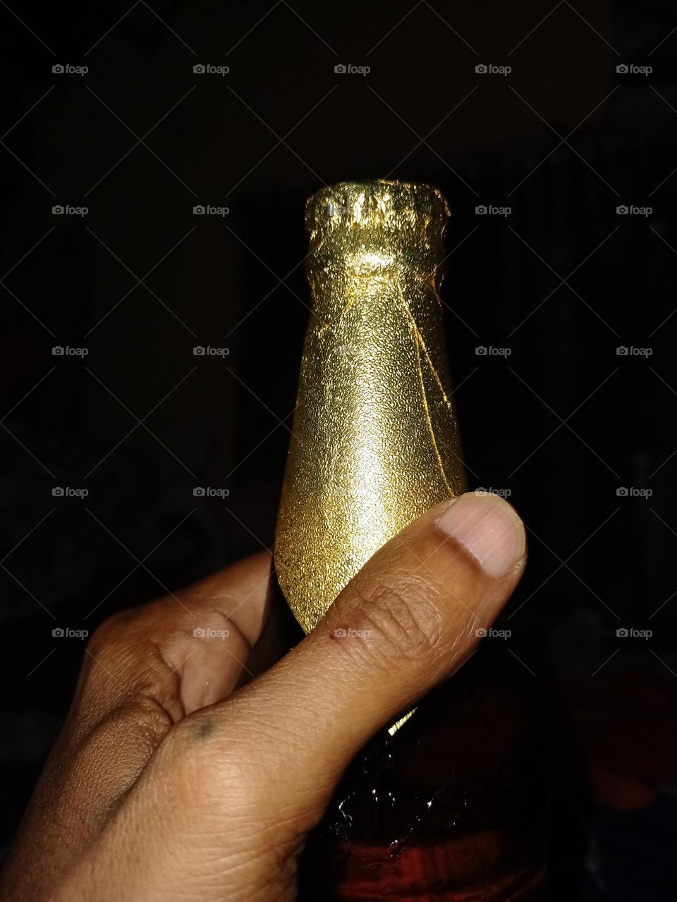 Young man holding beer bottle closeup night photography