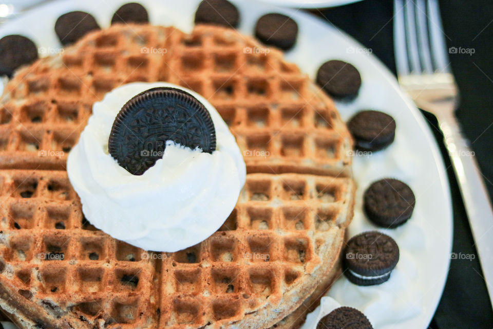 Yummy Oreo Waffles- homemade made Oreo waffles topped with cream and more cookies.