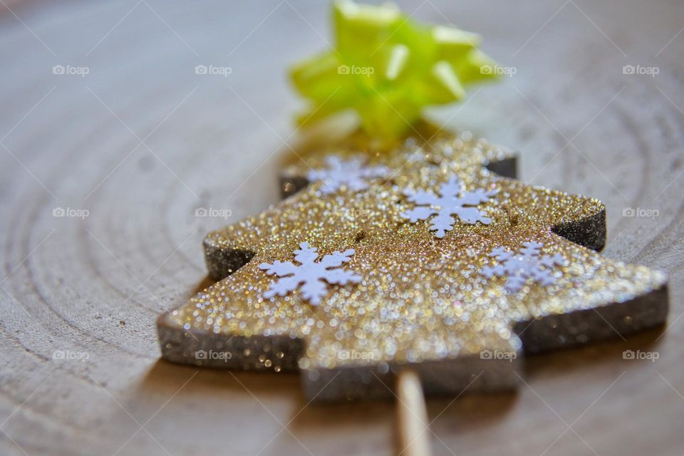 Wooden Christmas tree with glitter and white snowflakes.