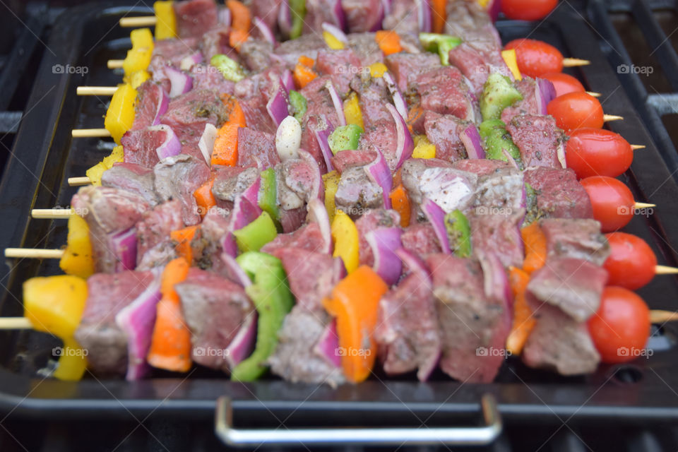 Symmetry: colorful vegetables, cubed steak on skewers for shish kebab