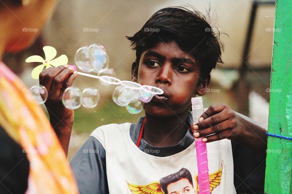 He didn't playing with that bubble..  He is trying to fullfill his sister's hungry..  #maturepoverty