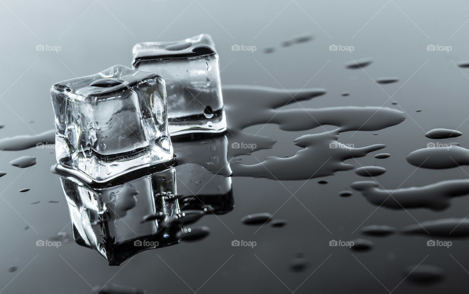 Close-up of melting ice cube with reflection