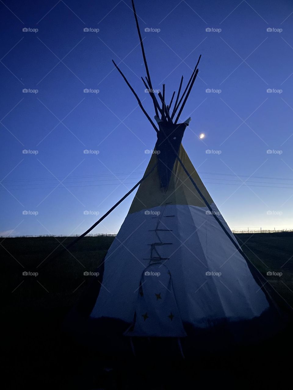 tipi lodge in Wyoming at nigh with moon 