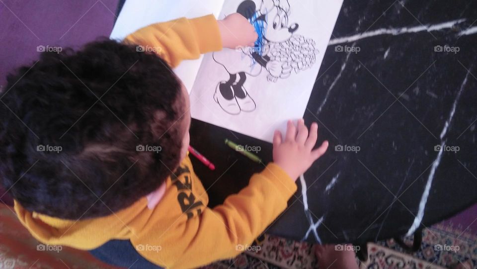 A child colors pictures.