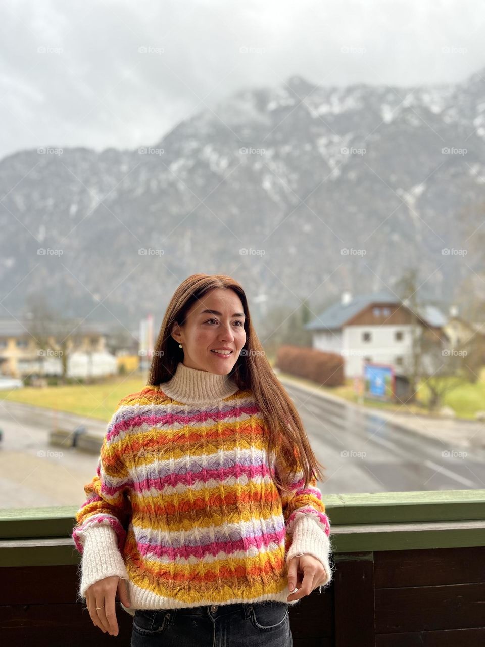 Beautiful young woman dressed with a colorful blouse, enjoying her morning while on a holiday in the Austrian mountains.