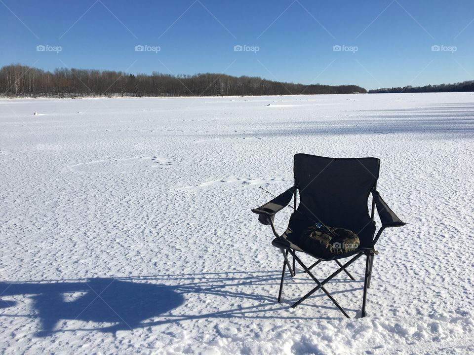 Lawn chair on an ice covered snowy river