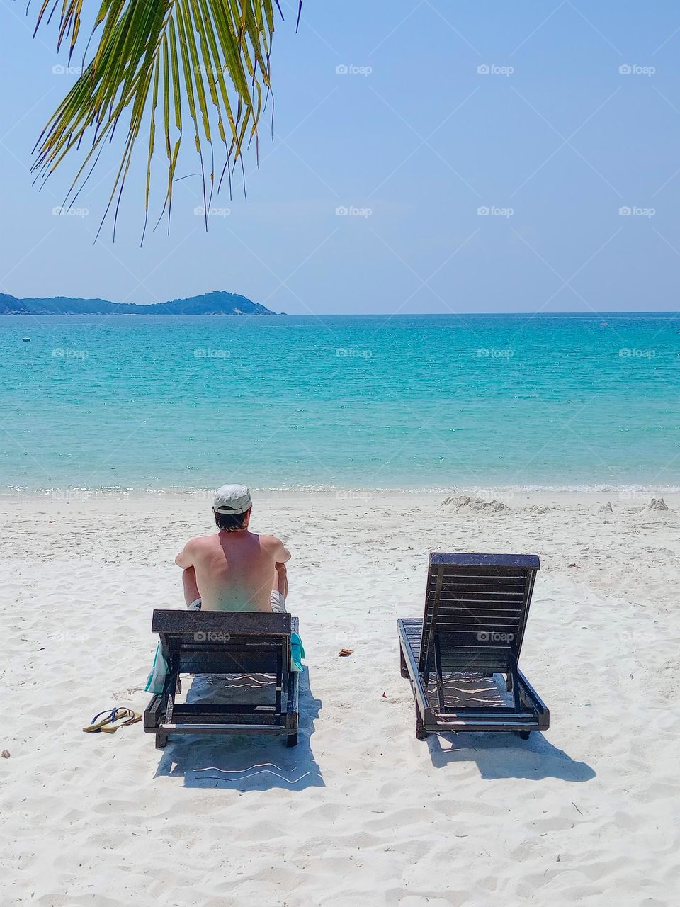 man on the beach chair looking at the sea