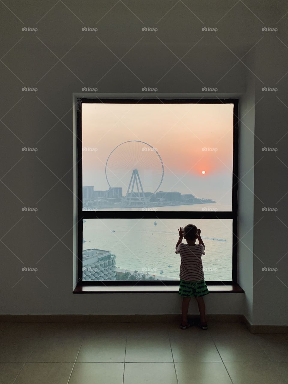 Beautiful colorful sunset with Ferris wheel from window 