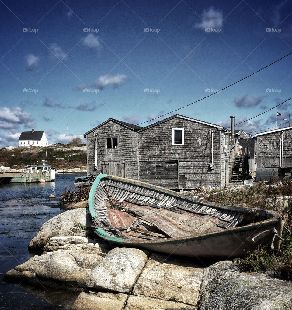 Broken boat shell beached on rocks in a Nova Scotia fishing village