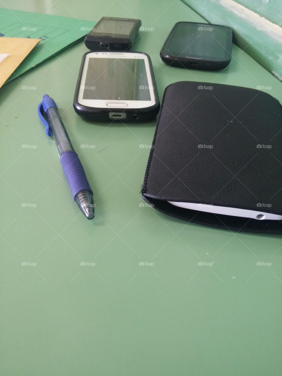 Close-up of mobile phone and pen on table