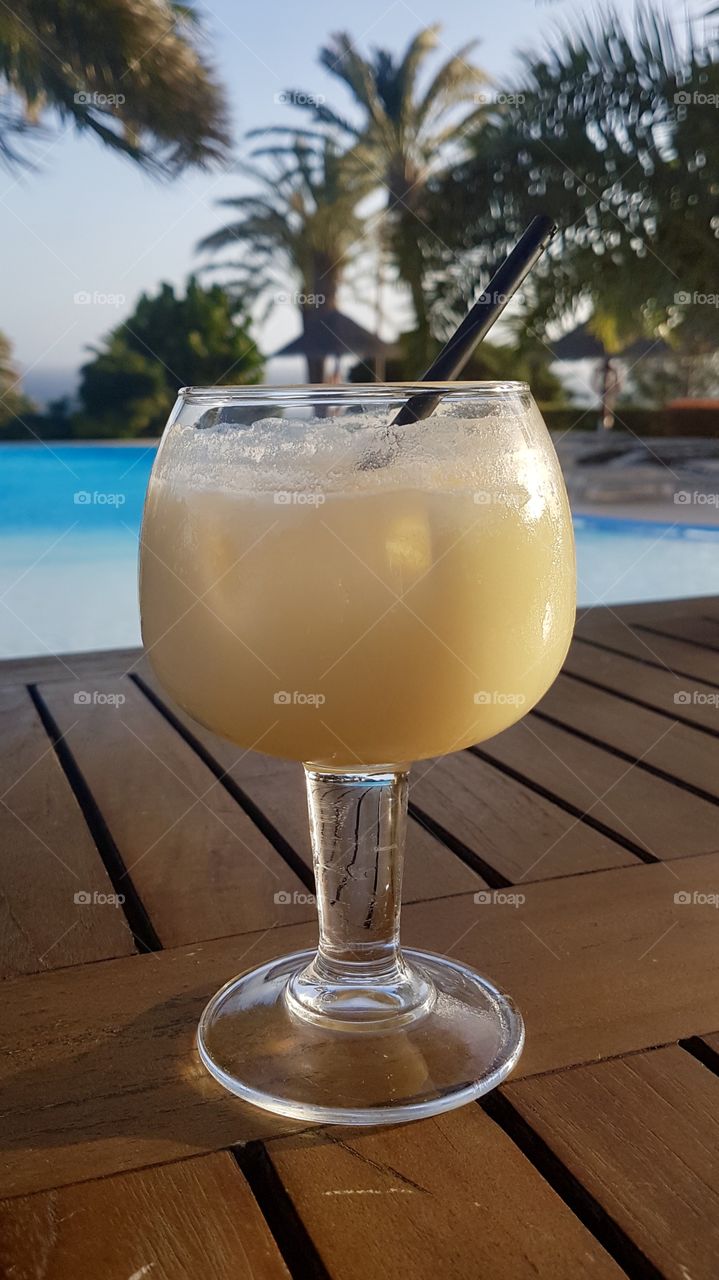 Enjoying a delicious Piña Colada drink by the poolside in fair weather - en god drink vid poolen i fint väder 
