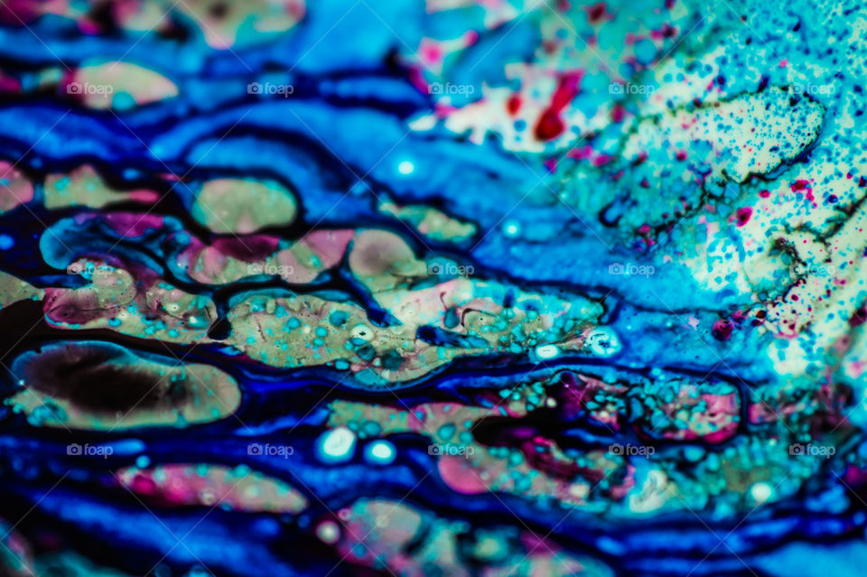 The ink to refill the printer cartridge was spilled onto the white washbasin and the paints blended into abstract drips and patterns.