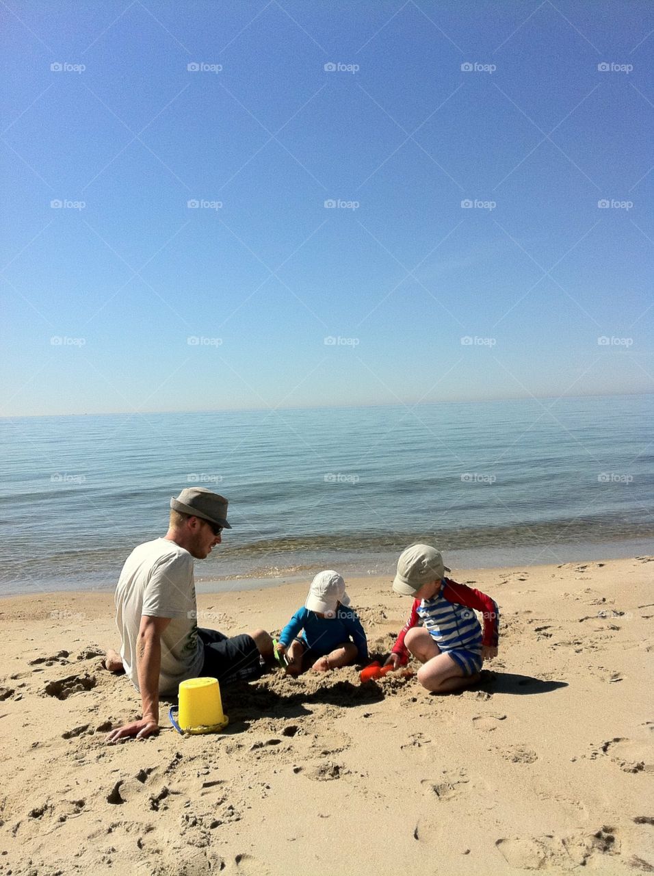 Dad and sons playing at the beach 