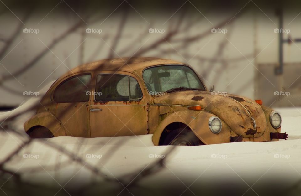 Old, rusty Volkswagen Beetle in the snow.