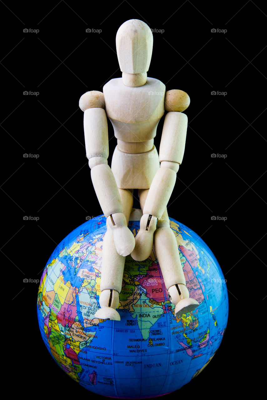 Wooden man sit on the globe