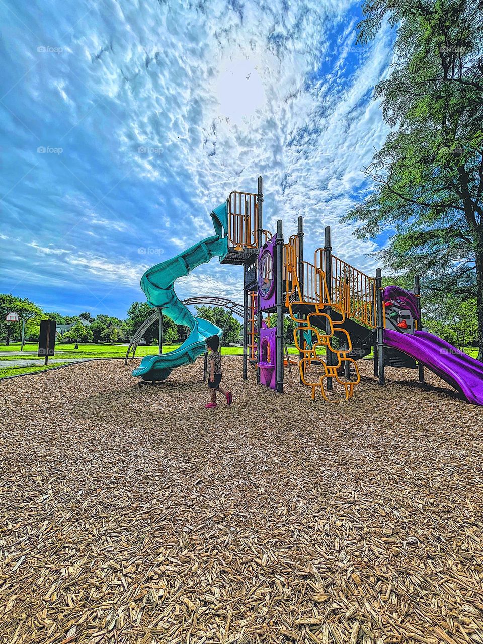 Toddler on the playground, larger than life playground equipment, playground equipment in the summertime, having fun in the summer 