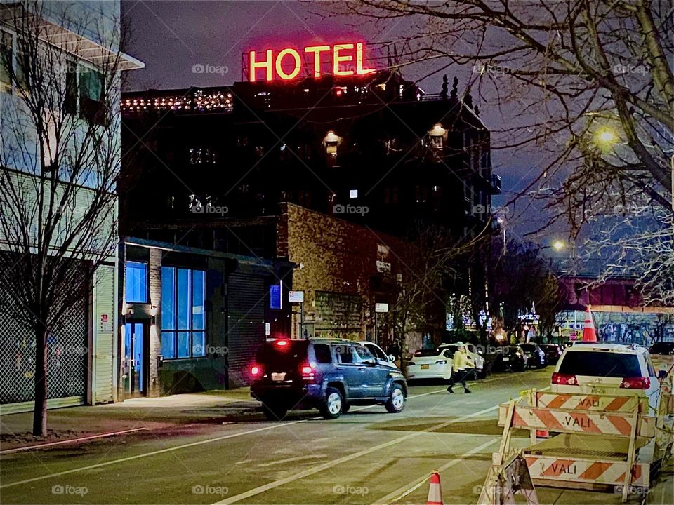 The „BOXHOUSE Hotel“ seen from „Boxstreet“ near the „Pulaski Bridge“ in „Newtown Creek“, „Greenpoint“, Bklyn. The large red neon sign on top of the building lets everyone know that a hotel with potential vacancies is there. 2023. Hypnotic Productions