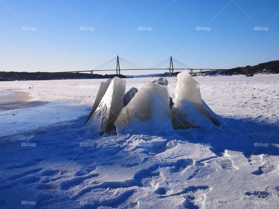 The cracked ice on the sea looks as beautiful as some sculpture.  Nature is something special.  Art is seen everywhere in nature.  In the background is a beautiful Uddevalla bridge/Sweden
