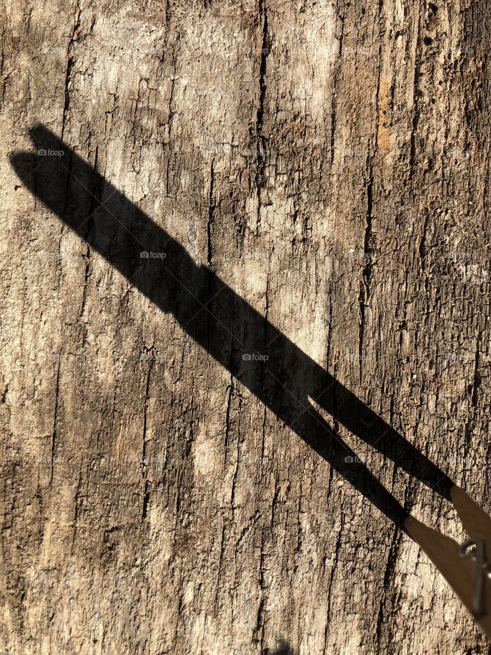 clothespin shadow on rustic textured wood