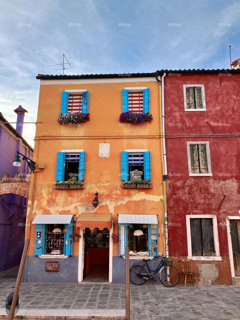 Bike propped up against a colourful shop in Burano 