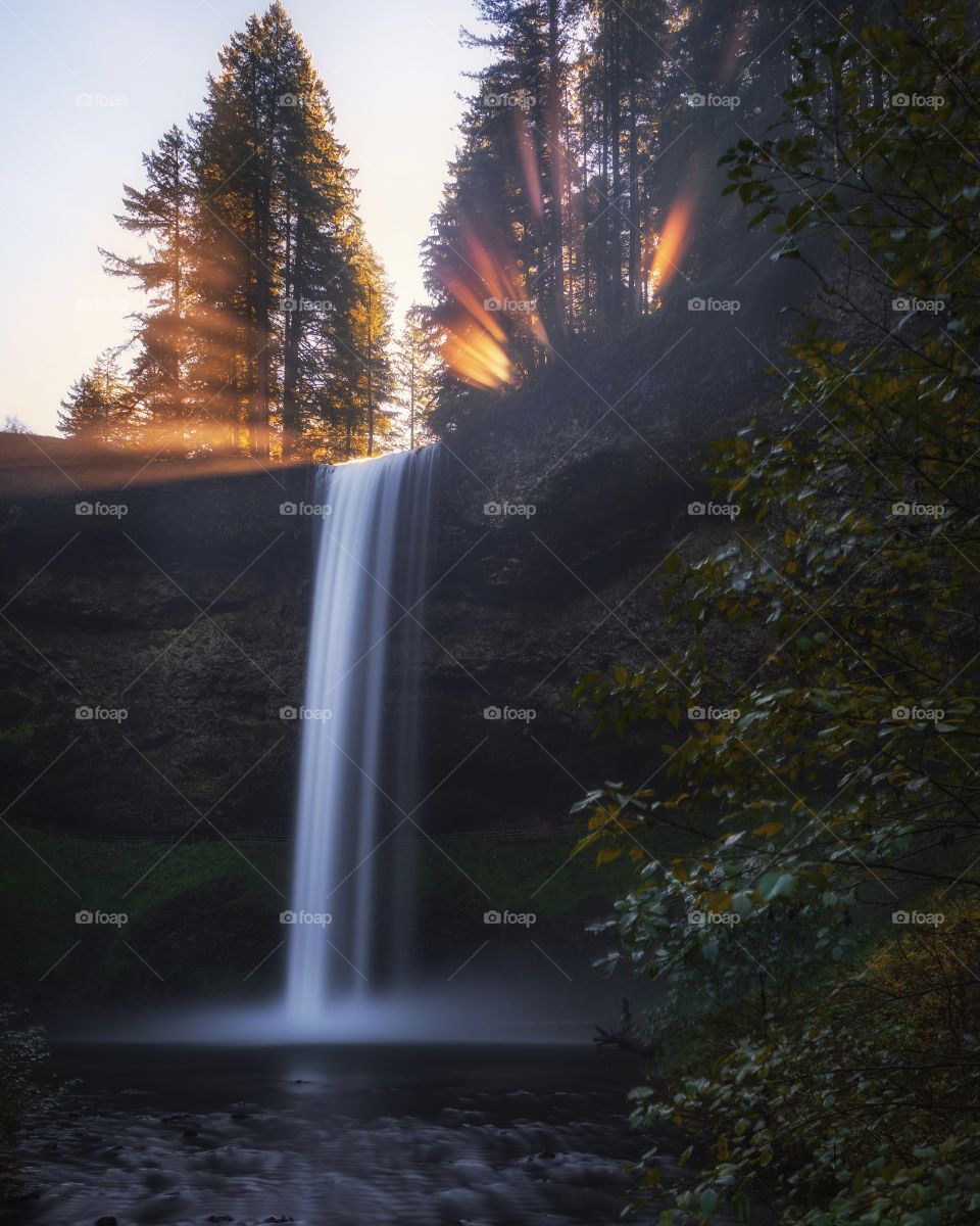 Sun beams over waterfall 