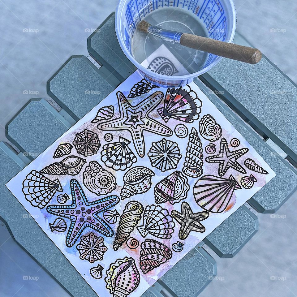 Painting seashells with a toddler, toddlers paint with water, magic painting sheets, mess free painting with kids, creating with kids, getting creative with toddlers, colorful seashells