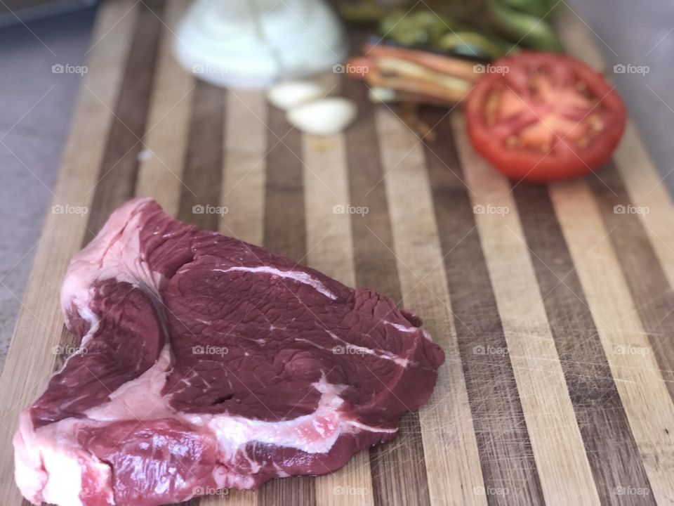 Fresh steak on chopping board with salad