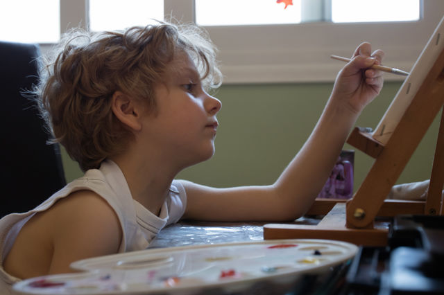 small blond kid painting