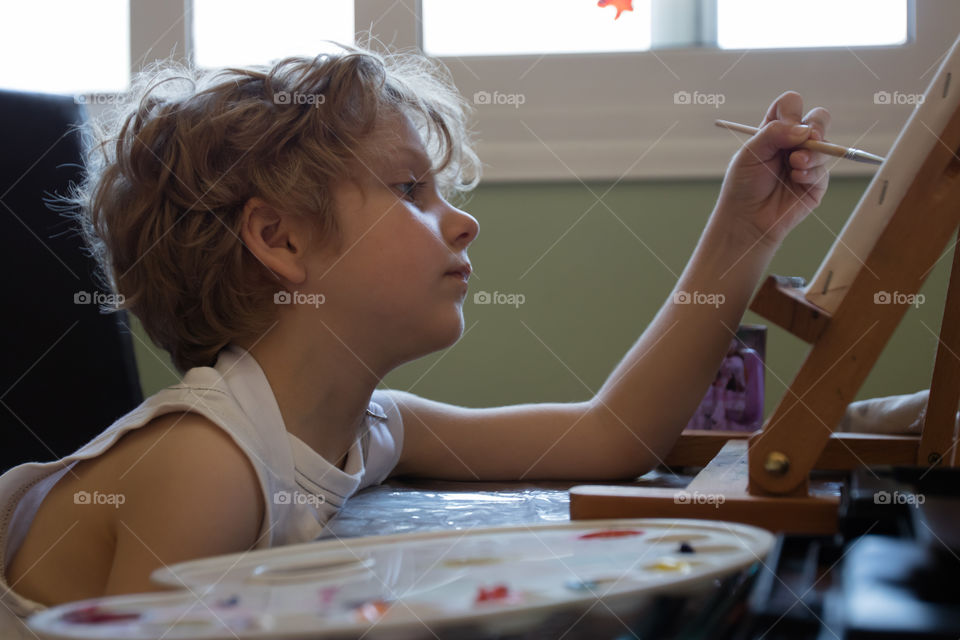 small blond kid painting