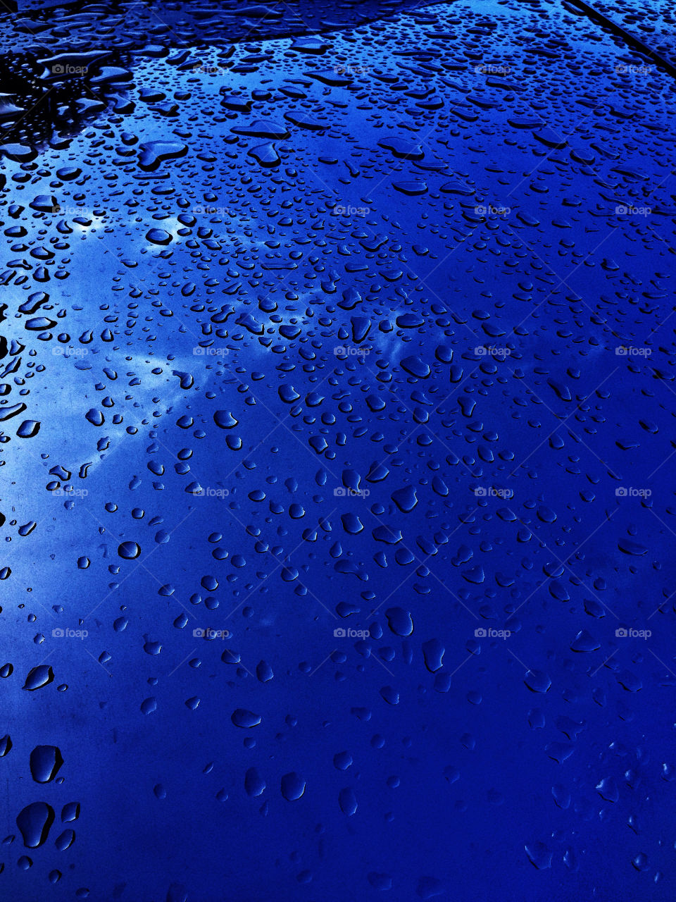 Water droplets collecting on a sheet of reflective stainless steel