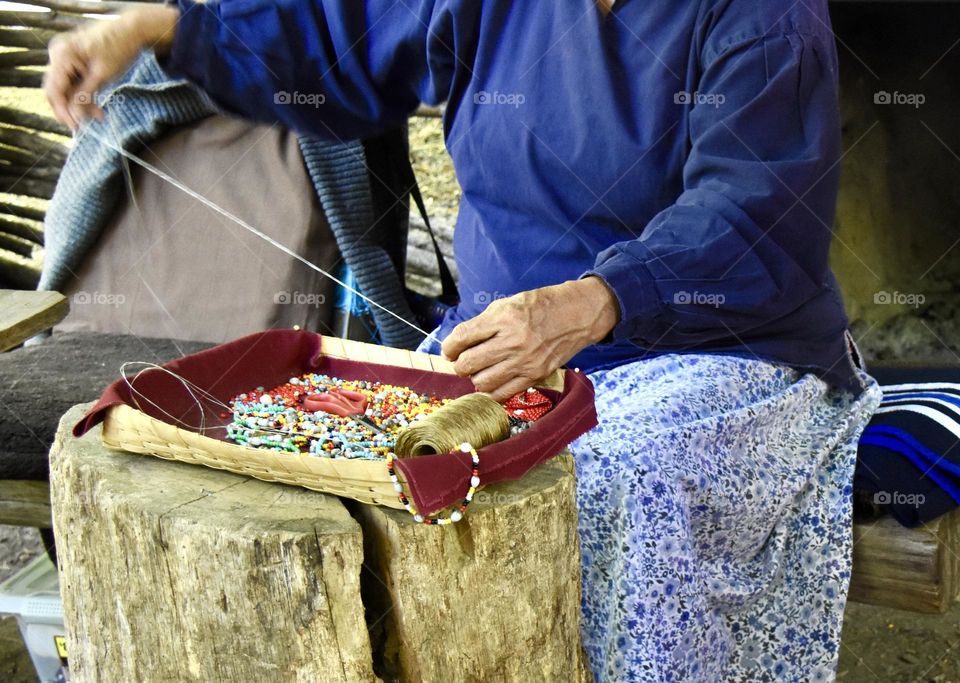 Woman weaving craft to sell 