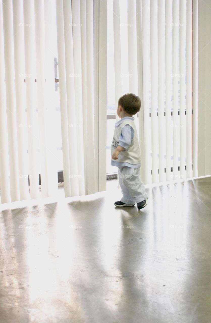 Little boy looking out a window