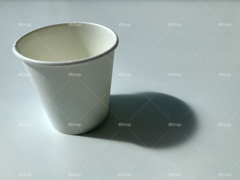 Paper cup with a shadow cast to the right