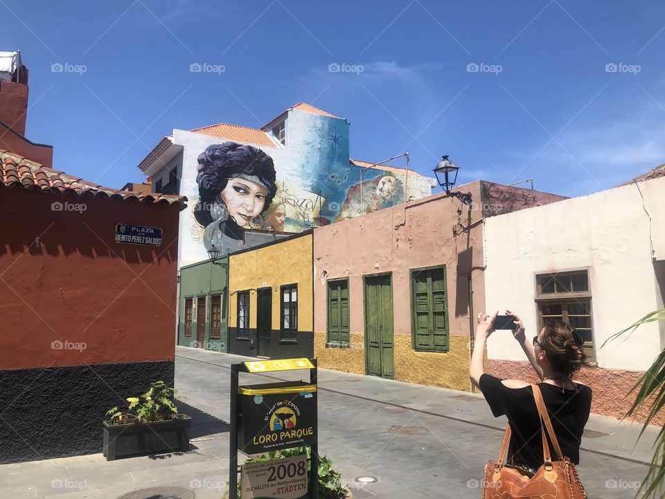 Tourist taking picture of mural 