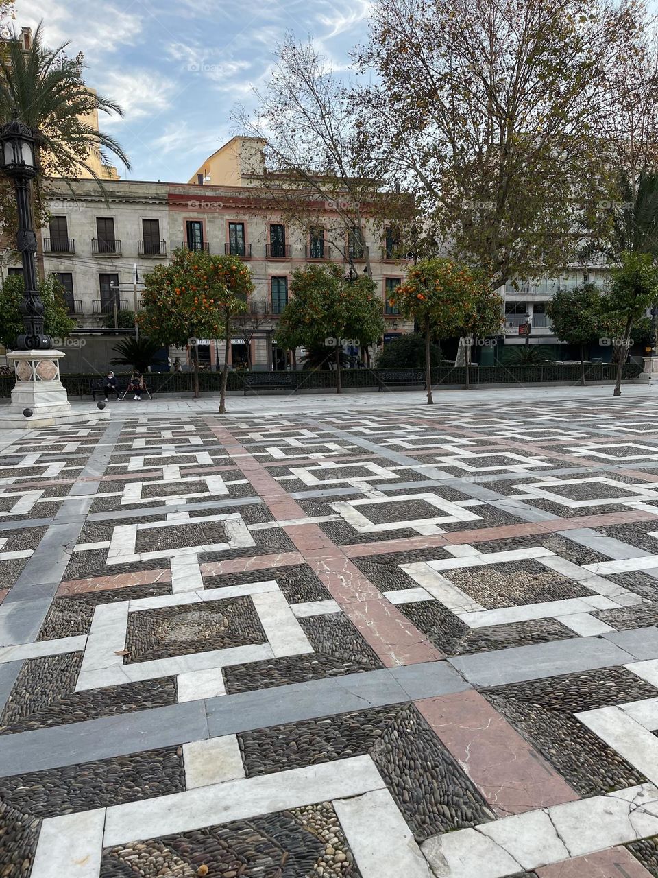 Squared and rectangular shapes made up of stone tiles covering one of the squares’ flooring in Sevilla, Spain 