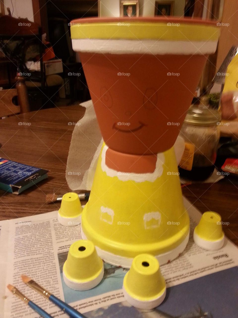 the progress of a yellow clay pot girl before she is assembled