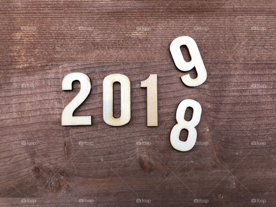 Happy new year 2019, bye 2018, conceptual composition with wooden numbers over wooden floor