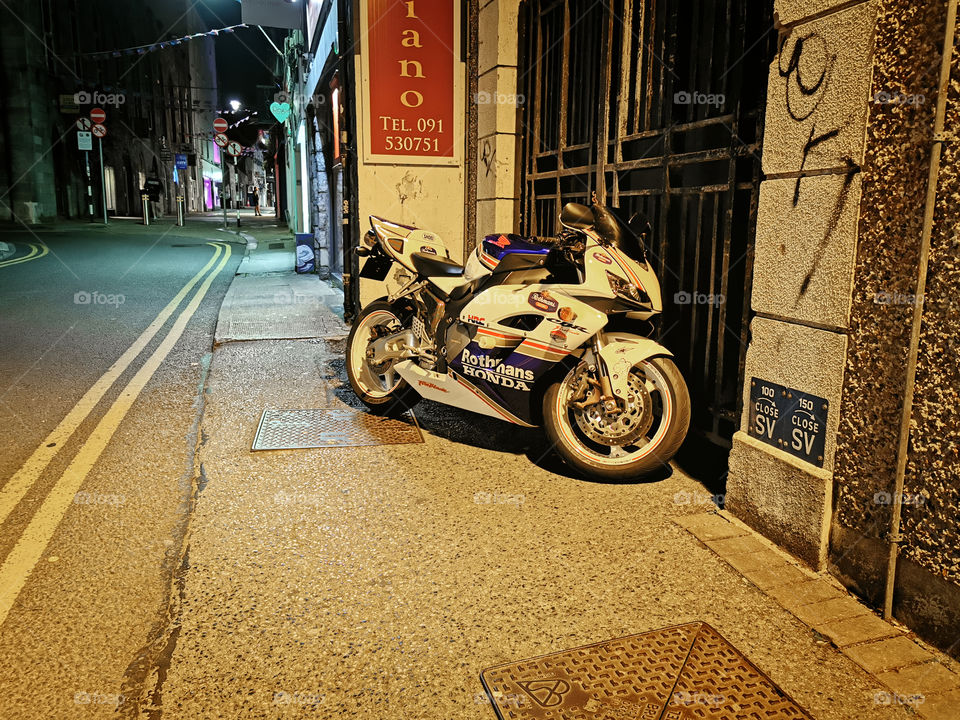 Motorbike parked in alley at night By the road