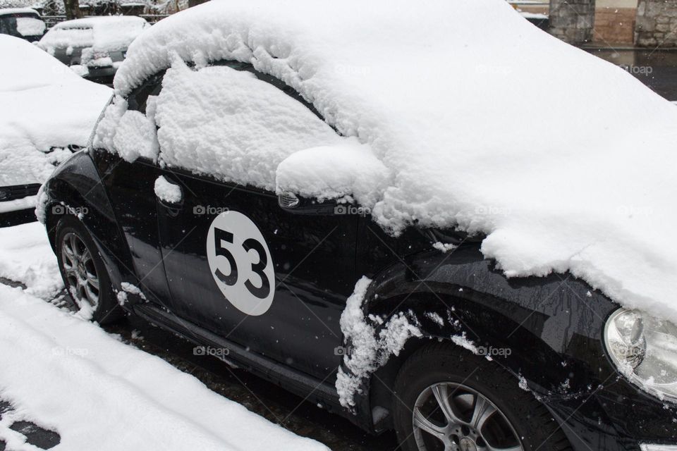 Car covered in snow along the road.