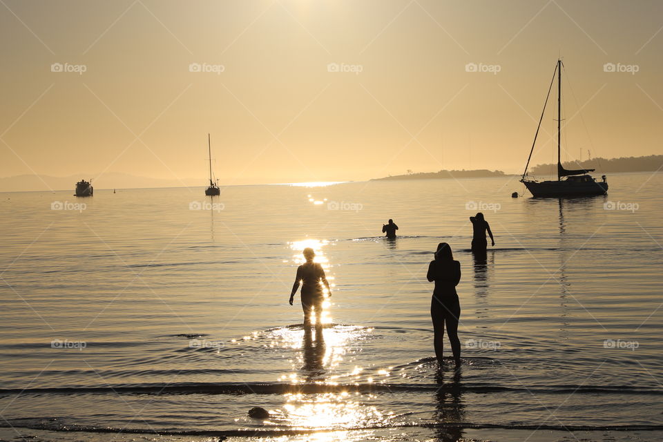 People  going in the ocean for early morning swim In enlightened ocean 