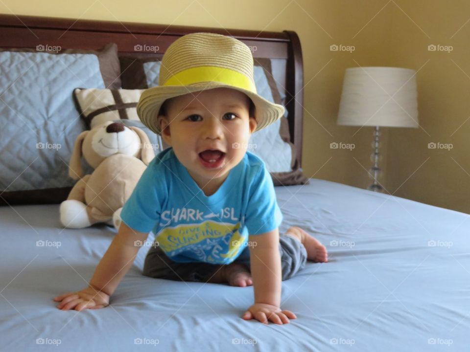 Happy baby boy on bed