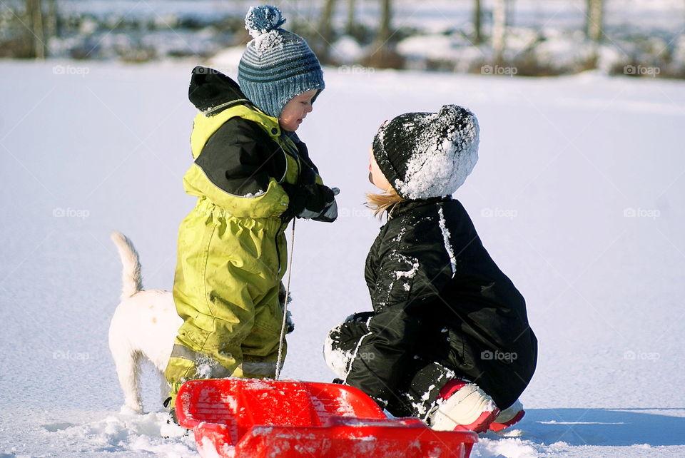 Brother and sister playing together in snow