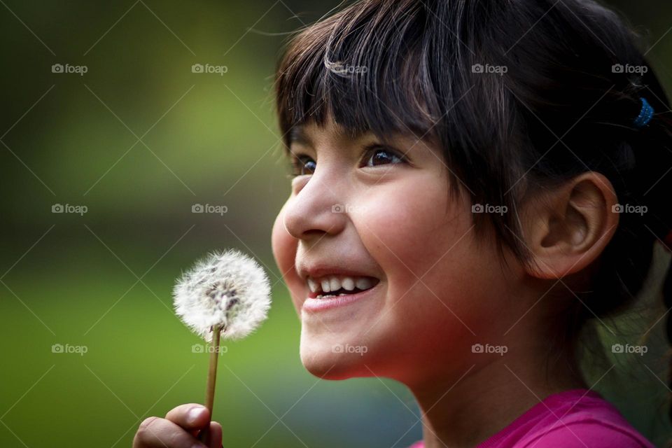 Happy girl with a dandelion