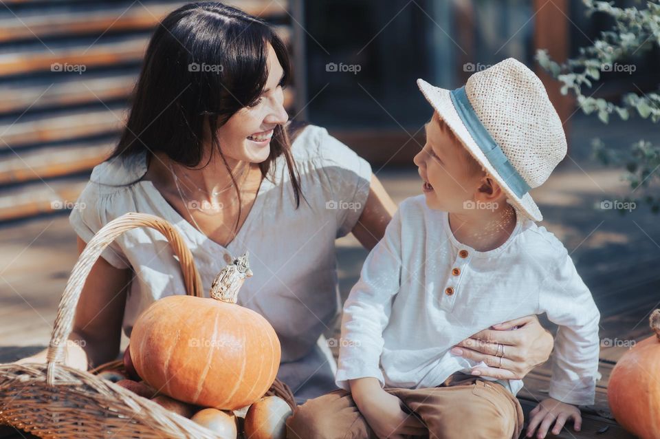 Mom and boy with orange pumpkin basket, autumn vibes