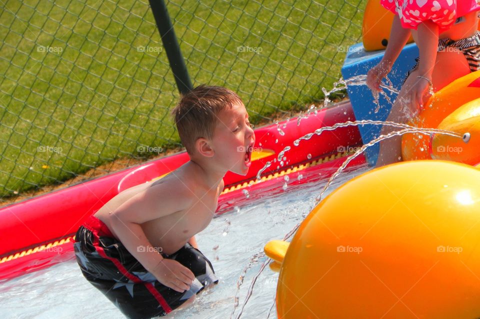 My little boy playing in the pool catching water with his mouth