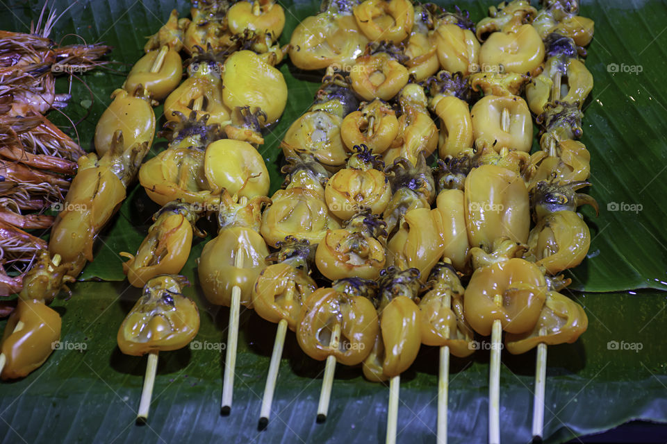 Grilled marinated squid with seafood sauce On banana leaf With the heat.