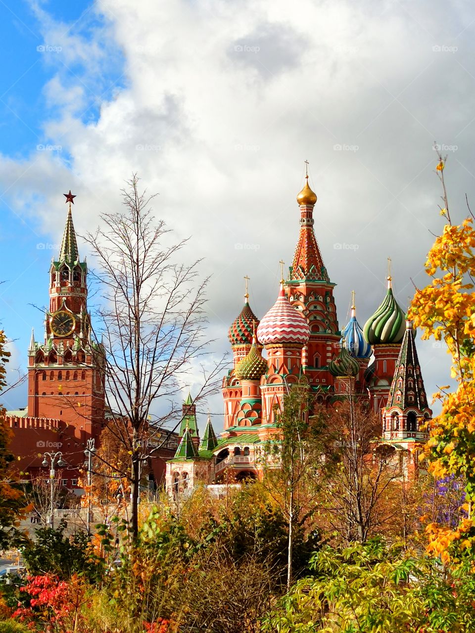 Moscow.  Autumn.  View from the Zaryadye park.  Autumn trees.  St. Basil's Cathedral and Spasskaya Tower with chimes. Color contrast